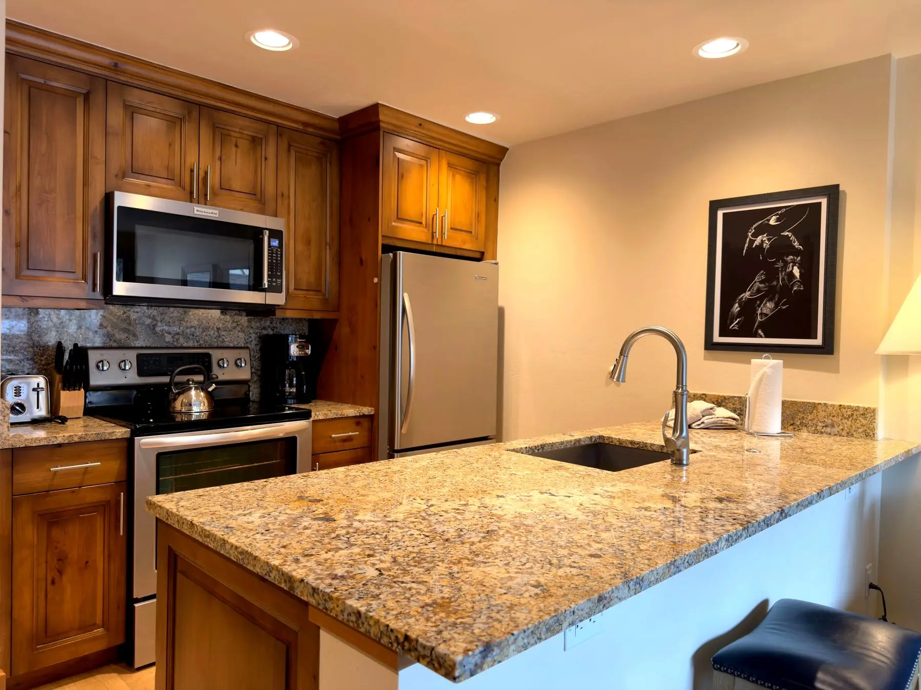 Kitchen island and sink with framed artwork
