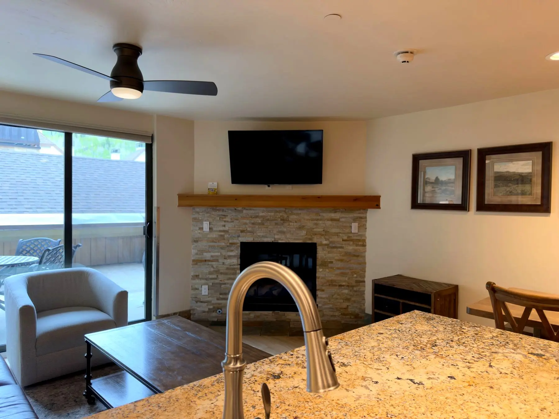 Living area with corner fireplace and ceiling fan