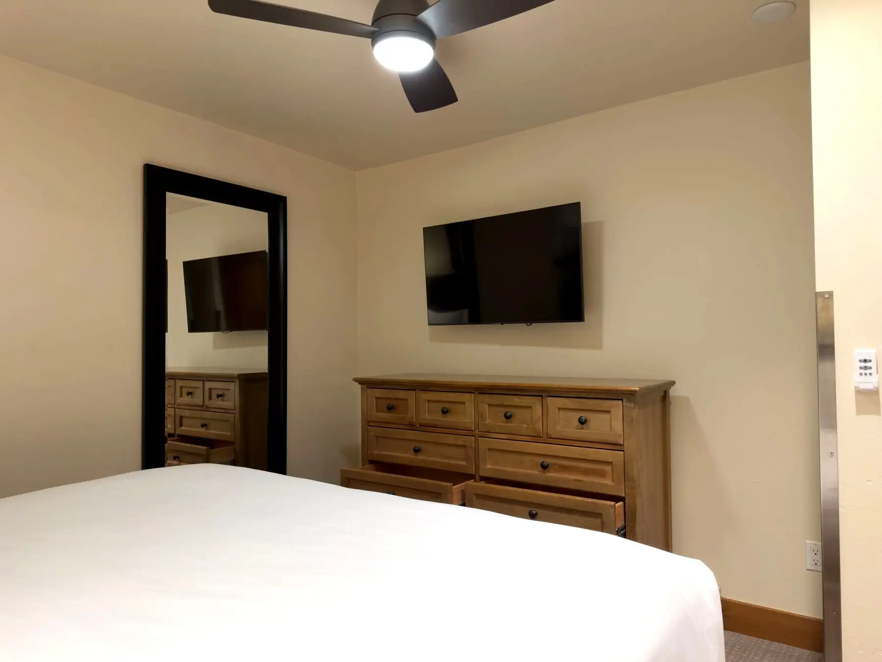 Primary bedroom dresser and mounted TV